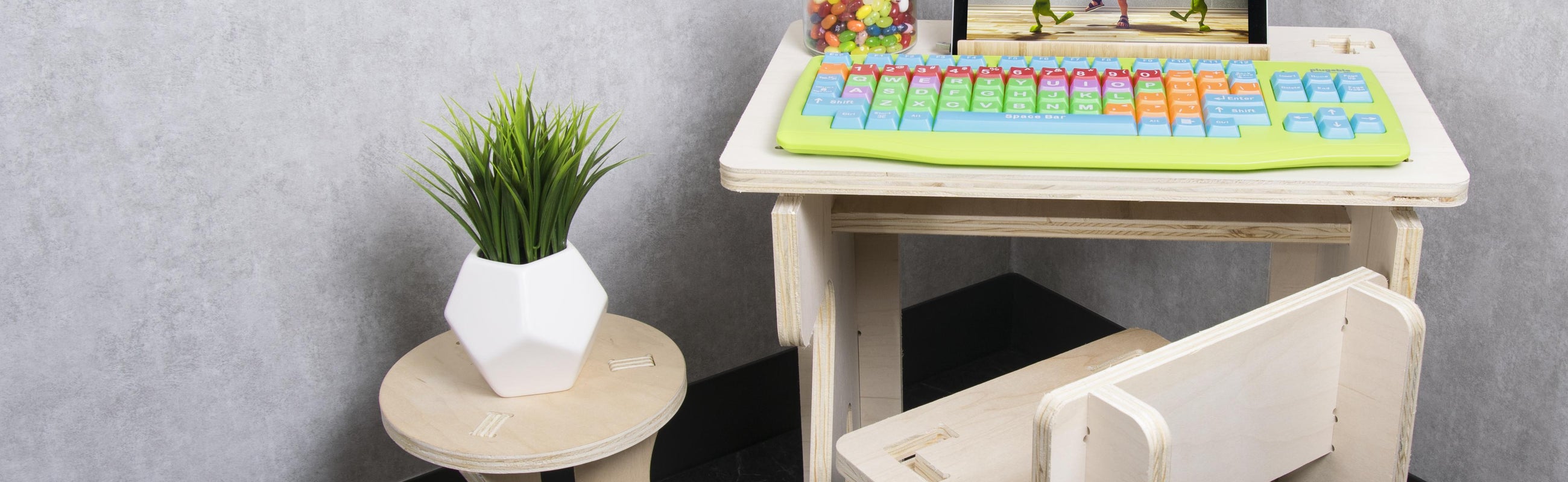 An image of the USB-EZK-G Kids Keyboard with some kid-sized furniture, tablet, and other décor.