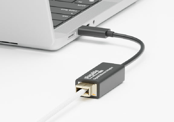 A close up image of an ethernet cable connected to the USBC-E1000 that is connected to a Macbook.
