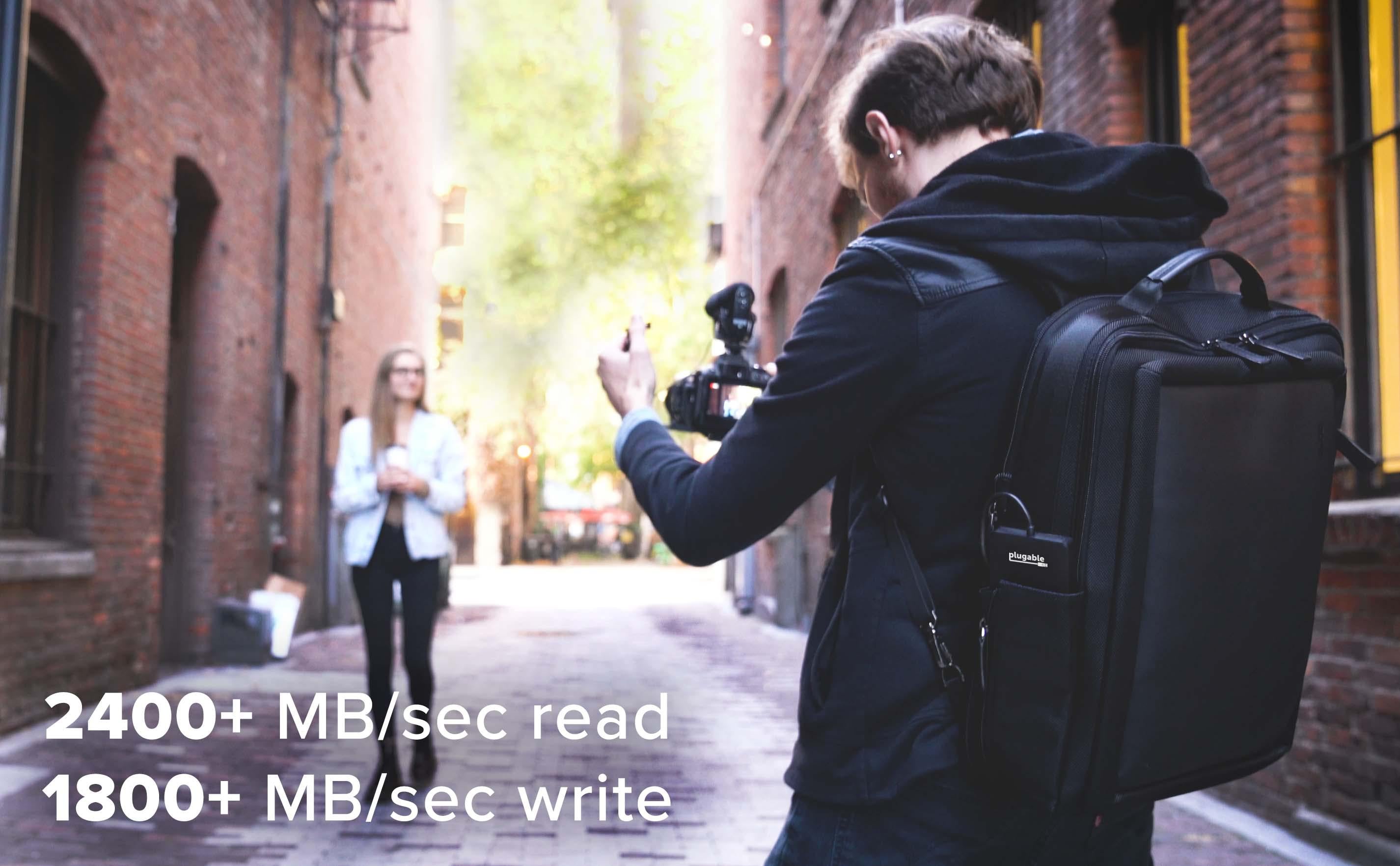 Image of someone taking a picture of their friend, with text that says 2400+ MB/sec read, 1800+ MB/sec write